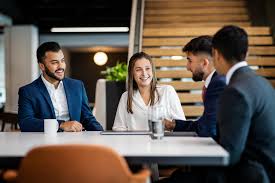 back view of woman wearing a backpack and beanie waiting to cross the road on a busy street at night in New York City, USA